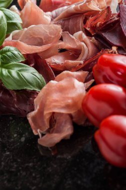 Jambon karışımı. Jambon. Geleneksel İtalyan ve İspanyol Tuzlama, Sigara, otlar ve karanlık taş zemin üzerine domates kuru tedavi çanak - jamon Serrano ve prosciutto crudo dilimlenmiş. Uzay kopyalayın. Portre