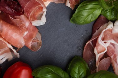 Jambon karışımı. Jambon. Geleneksel İtalyan ve İspanyol Tuzlama, Sigara, otlar ve karanlık taş zemin üzerine domates kuru tedavi çanak - jamon Serrano ve prosciutto crudo dilimlenmiş. Uzay kopyalayın. Portre