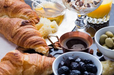 Kahvaltı çeşitli yoğurt, granola, kahve, meyve suyu, kruvasan, zeytin. Meze sabah yemekleri ile karıştırın. Koyu arka plan üzerinde sağlıklı, taze, lezzetli yemek. Üstten Görünüm. Kopya alanı