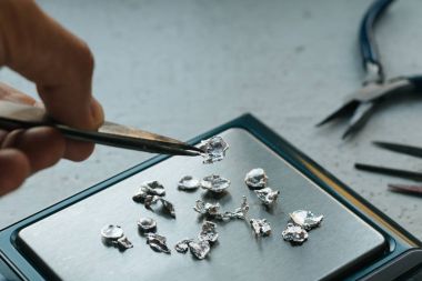 Takı araçları. Takı. Goldsmith işyeri, çalışma alanında açık renkli. El tekne. Atölye. Üretim. Ağırlık pullarla granül metal gümüş ve platin. Portre. Tonda