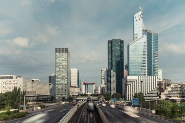 Modern binalar ve Paris iş dinamik sokak trafiğe La Defense bölge. Cityscape ile cam cephe gökdelenler bulutlu bir günde. Ekonomi, finans, yol ağ ve şehir trafik konsepti