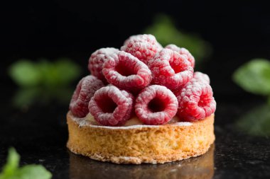 Ahududulu tart tatlı koyu arka plan üzerinde. Geleneksel Fransız tatlı pasta. Lezzetli, iştah açıcı, ev yapımı Pasta krema, taze meyveler ve meyve ile. Alan, closeup kopyalayın. Seçici odak