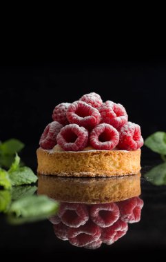 Ahududulu tart tatlı koyu arka plan üzerinde. Geleneksel Fransız tatlı pasta. Lezzetli, iştah açıcı, ev yapımı Pasta krema, taze meyveler ve meyve ile. Alan, closeup kopyalayın. Seçici odak