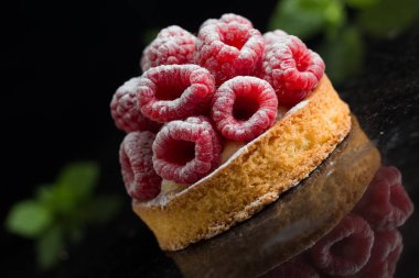 Ahududulu tart tatlı koyu arka plan üzerinde. Geleneksel Fransız tatlı pasta. Lezzetli, iştah açıcı, ev yapımı Pasta krema, taze meyveler ve meyve ile. Alan, closeup kopyalayın. Seçici odak