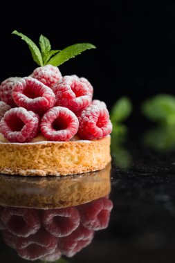 Ahududulu tart tatlı koyu arka plan üzerinde. Geleneksel Fransız tatlı pasta. Lezzetli, iştah açıcı, ev yapımı Pasta krema, taze meyveler ve meyve ile. Alan, closeup kopyalayın. Seçici odak