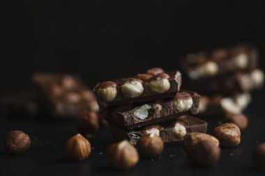Çikolata parçaları ve karanlık arduvaz arka plan kopya alanı ile fındık bar. Çikolata arka plan. Üstten Görünüm. Tonda