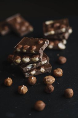 Çikolata parçaları ve karanlık arduvaz arka plan kopya alanı ile fındık bar. Çikolata arka plan. Üstten Görünüm. Tonda