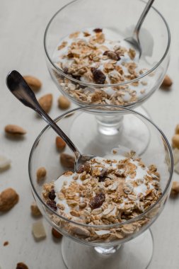 Granola yoğurt, fındık ve açık renkli cam kase meyve ile. Kahvaltı için lezzetli, sağlıklı tatlı tatlı. Mısır gevreği, müsli. Kopya alanı, portre