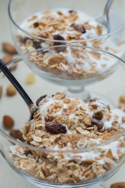 Granola yoğurt, fındık ve açık renkli cam kase meyve ile. Kahvaltı için lezzetli, sağlıklı tatlı tatlı. Mısır gevreği, müsli. Kopya alanı, portre