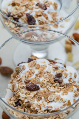 Granola yoğurt, fındık ve açık renkli cam kase meyve ile. Kahvaltı için lezzetli, sağlıklı tatlı tatlı. Mısır gevreği, müsli. Kopya alanı, portre