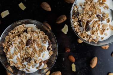 Granola yoğurt, fındık ve koyu arka plan üzerinde cam kase meyve ile. Kahvaltı için lezzetli, sağlıklı tatlı tatlı. Mısır gevreği, müsli. Kopya alanı, portre