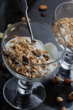 Granola yoğurt, fındık ve koyu arka plan üzerinde cam kase meyve ile. Kahvaltı için lezzetli, sağlıklı tatlı tatlı. Mısır gevreği, müsli. Kopya alanı, portre