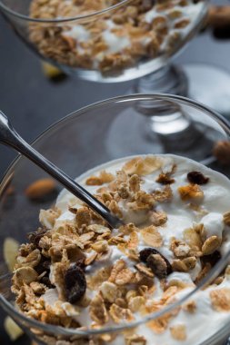 Granola yoğurt, fındık ve koyu arka plan üzerinde cam kase meyve ile. Kahvaltı için lezzetli, sağlıklı tatlı tatlı. Mısır gevreği, müsli. Kopya alanı, portre
