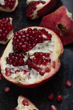 Karanlık mermer zemin üzerine kırmızı sulu nar. Sağlıklı, antioksidan, taze, gurme, lezzetli, organik meyve. Nar suyu için madde. Yakın çekim ve kopya alanı