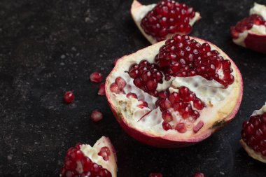 Karanlık mermer zemin üzerine kırmızı sulu nar. Sağlıklı, antioksidan, taze, gurme, lezzetli, organik meyve. Nar suyu için madde. Yakın çekim ve kopya alanı