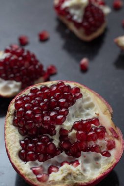 Karanlık mermer zemin üzerine kırmızı sulu nar. Sağlıklı, antioksidan, taze, gurme, lezzetli, organik meyve. Nar suyu için madde. Yakın çekim ve kopya alanı