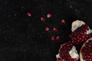 Karanlık mermer zemin üzerine kırmızı sulu nar. Sağlıklı, antioksidan, taze, gurme, lezzetli, organik meyve. Nar suyu için madde. Yakın çekim ve kopya alanı