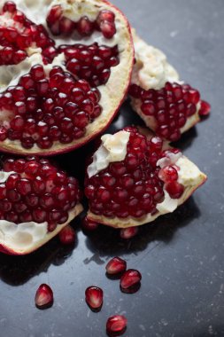 Karanlık mermer zemin üzerine kırmızı sulu nar. Sağlıklı, antioksidan, taze, gurme, lezzetli, organik meyve. Nar suyu için madde. Yakın çekim ve kopya alanı