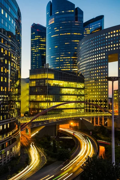 Ουρανοξύστες στο Παρίσι επιχειρηματική περιοχή La Defense. Ευρωπαϊκή νύχτα Σίτισκεϊπ με δυναμική δρόμο κυκλοφορίας, φώτα αυτοκινήτων και γυάλινες προσόψεις των σύγχρονων κτιρίων. Οικονομίας, οικονομικών, ιδέα μεταφοράς. Ήπια — Φωτογραφία Αρχείου