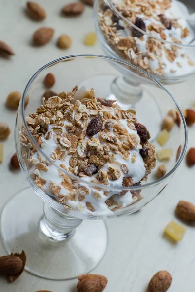 Granola yoğurt, fındık ve açık renkli cam kase meyve ile. Kahvaltı için lezzetli, sağlıklı tatlı tatlı. Mısır gevreği, müsli. Kopya alanı, portre