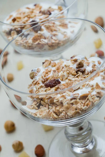 Granola con yogurt, noci e frutta in ciotola di vetro su fondo chiaro. Delizioso dolce dolce sano per colazione. Cereali, muesli. Copia spazio, primo piano — Foto Stock