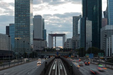 Modern binalar ve Paris iş dinamik sokak trafiğe La Defense bölge. Cityscape ile cam cephe gökdelenler bulutlu bir günde. Ekonomi, finans, yol ağ ve şehir trafik konsepti