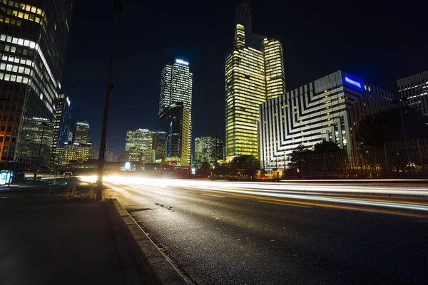 Paris iş içinde gökdelenler La Defense bölge. Avrupa gece cityscape dinamik sokak trafik, araba ışıklar ve modern binalar cam cephe ile. Ekonomi, Maliye, Ulaştırma kavramı. Tonda