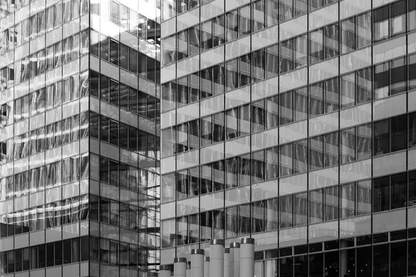 Gratte-ciel façades vitrées dans le centre d'affaires de Paris La Défense. Architecture urbaine, immeubles de bureaux modernes. Fond abstrait avec réflexion du ciel. Économie, finance concept d'activité. Noir et blanc — Photo