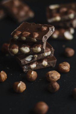 Çikolata parçaları ve karanlık arduvaz arka plan kopya alanı ile fındık bar. Çikolata arka plan. Üstten Görünüm. Tonda