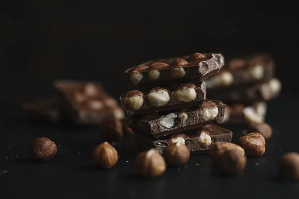 Schokoriegel und Nüsse auf dunklem Schiefergrund mit Kopierraum. Schokoladenhintergrund. Ansicht von oben. gemildert — Stockfoto
