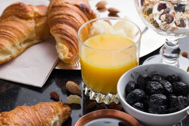 Kahvaltı çeşitli yoğurt, granola, kahve, meyve suyu, kruvasan, zeytin. Meze sabah yemekleri ile karıştırın. Koyu arka plan üzerinde sağlıklı, taze, lezzetli yemek