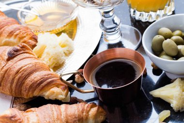 Kahvaltı çeşitli yoğurt, granola, kahve, meyve suyu, kruvasan, zeytin. Meze sabah yemekleri ile karıştırın. Koyu arka plan üzerinde sağlıklı, taze, lezzetli yemek