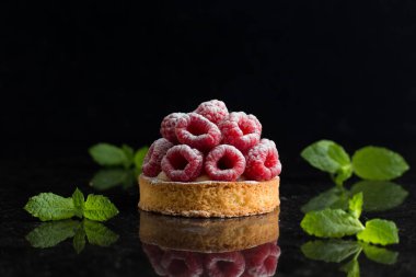 Ahududulu tart tatlı koyu arka plan üzerinde. Geleneksel Fransız tatlı pasta. Lezzetli, iştah açıcı, ev yapımı Pasta krema, taze meyveler ve meyve ile. Alan, closeup kopyalayın. Seçici odak