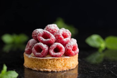 Ahududulu tart tatlı koyu arka plan üzerinde. Geleneksel Fransız tatlı pasta. Lezzetli, iştah açıcı, ev yapımı Pasta krema, taze meyveler ve meyve ile. Alan, closeup kopyalayın. Seçici odak
