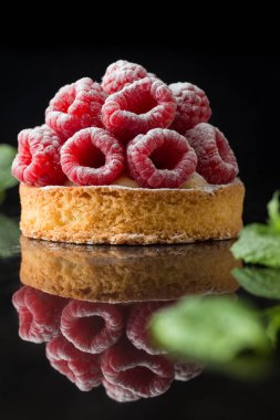 Ahududulu tart tatlı koyu arka plan üzerinde. Geleneksel Fransız tatlı pasta. Lezzetli, iştah açıcı, ev yapımı Pasta krema, taze meyveler ve meyve ile. Alan, closeup kopyalayın. Seçici odak