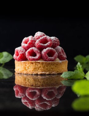 Ahududulu tart tatlı koyu arka plan üzerinde. Geleneksel Fransız tatlı pasta. Lezzetli, iştah açıcı, ev yapımı Pasta krema, taze meyveler ve meyve ile. Alan, closeup kopyalayın. Seçici odak