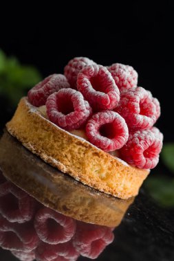 Ahududulu tart tatlı koyu arka plan üzerinde. Geleneksel Fransız tatlı pasta. Lezzetli, iştah açıcı, ev yapımı Pasta krema, taze meyveler ve meyve ile. Alan, closeup kopyalayın. Seçici odak
