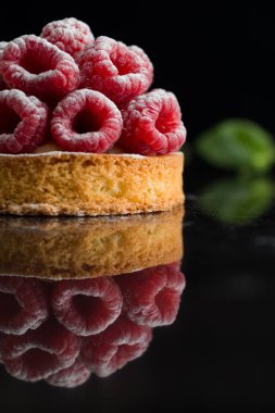 Ahududulu tart tatlı koyu arka plan üzerinde. Geleneksel Fransız tatlı pasta. Lezzetli, iştah açıcı, ev yapımı Pasta krema, taze meyveler ve meyve ile. Alan, closeup kopyalayın. Seçici odak