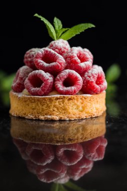 Ahududulu tart tatlı koyu arka plan üzerinde. Geleneksel Fransız tatlı pasta. Lezzetli, iştah açıcı, ev yapımı Pasta krema, taze meyveler ve meyve ile. Alan, closeup kopyalayın. Seçici odak