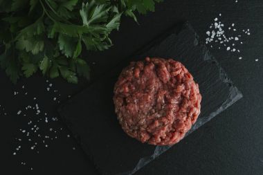 Çiğ biftek. Sığır eti çiğ et baharat, ot ve yumurta sarısı ile kıyılmış. Taze, baharatlı, lezzetli, gurme yemek ile kopya alanı, koyu arka plan üzerinde yakın çekim