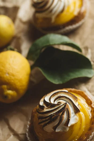 Lemon pie on the table with citrus fruits. Traditional french sweet pastry tart. Delicious, appetizing, homemade dessert with lemon cream. Copy space, closeup. Selective focus. Toned