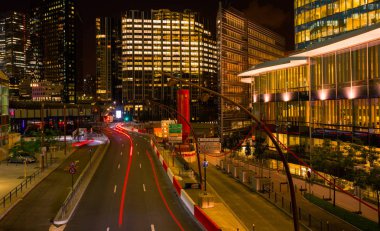 Paris iş içinde gökdelenler La Defense bölge. Avrupa gece cityscape dinamik sokak trafik, araba ışıklar ve modern binalar cam cephe ile. Ekonomi, Maliye, Ulaştırma kavramı. Tonda