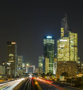 Paris iş içinde gökdelenler La Defense bölge. Avrupa gece cityscape dinamik sokak trafik, araba ışıklar ve modern binalar cam cephe ile. Ekonomi, Maliye, Ulaştırma kavramı. Tonda
