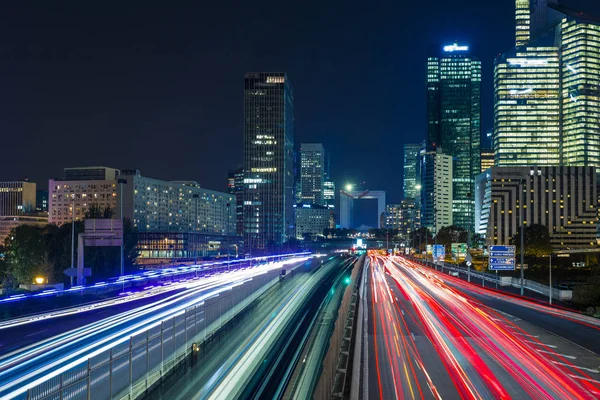 Paris iş içinde gökdelenler La Defense bölge. Avrupa gece cityscape dinamik sokak trafik, araba ışıklar ve modern binalar cam cephe ile. Ekonomi, Maliye, Ulaştırma kavramı. Tonda