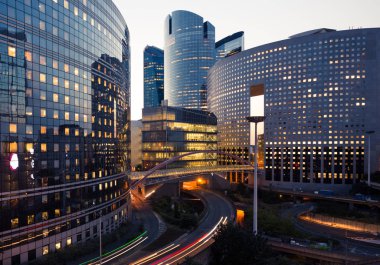 Paris iş içinde gökdelenler La Defense bölge. Avrupa gece cityscape dinamik sokak trafik, araba ışıklar ve modern binalar cam cephe ile. Ekonomi, Maliye, Ulaştırma kavramı. Tonda
