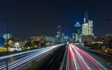 Paris iş içinde gökdelenler La Defense bölge. Avrupa gece cityscape dinamik sokak trafik, araba ışıklar ve modern binalar cam cephe ile. Ekonomi, Maliye, Ulaştırma kavramı. Tonda