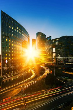 Paris iş modern binalar La Defense bölge. Cam cephe gökdelenler mavi gökyüzünde güneş ışınları ile parlak güneşli bir günde. Ekonomi, ticari faaliyet, yol ağ ve şehir trafik konsepti