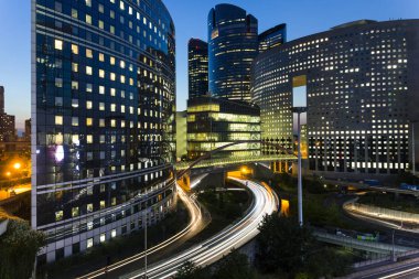 Paris iş içinde gökdelenler La Defense bölge. Avrupa gece cityscape dinamik sokak trafik, araba ışıklar ve modern binalar cam cephe ile. Ekonomi, Maliye, Ulaştırma kavramı. Tonda