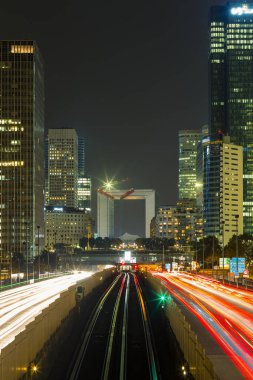 Paris iş içinde gökdelenler La Defense bölge. Avrupa gece cityscape dinamik sokak trafik, araba ışıklar ve modern binalar cam cephe ile. Ekonomi, Maliye, Ulaştırma kavramı. Tonda