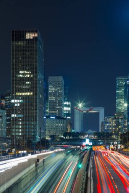 Paris iş içinde gökdelenler La Defense bölge. Avrupa gece cityscape dinamik sokak trafik, araba ışıklar ve modern binalar cam cephe ile. Ekonomi, Maliye, Ulaştırma kavramı. Tonda